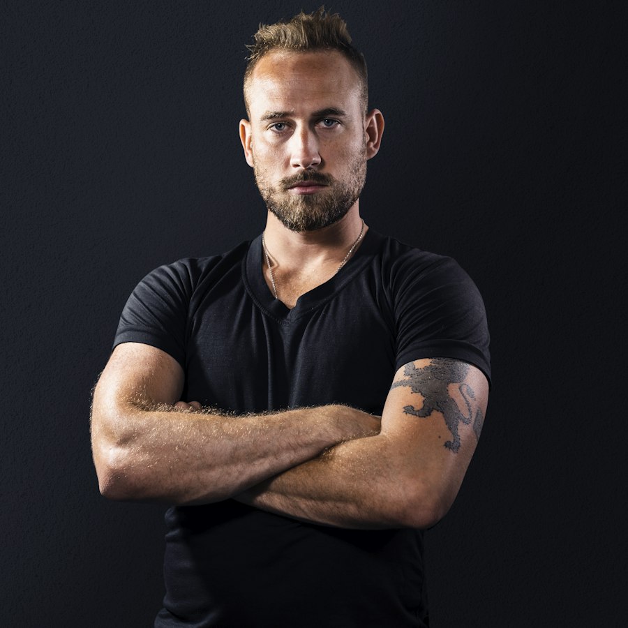 Coach portrait, arms crossed, dark studio background